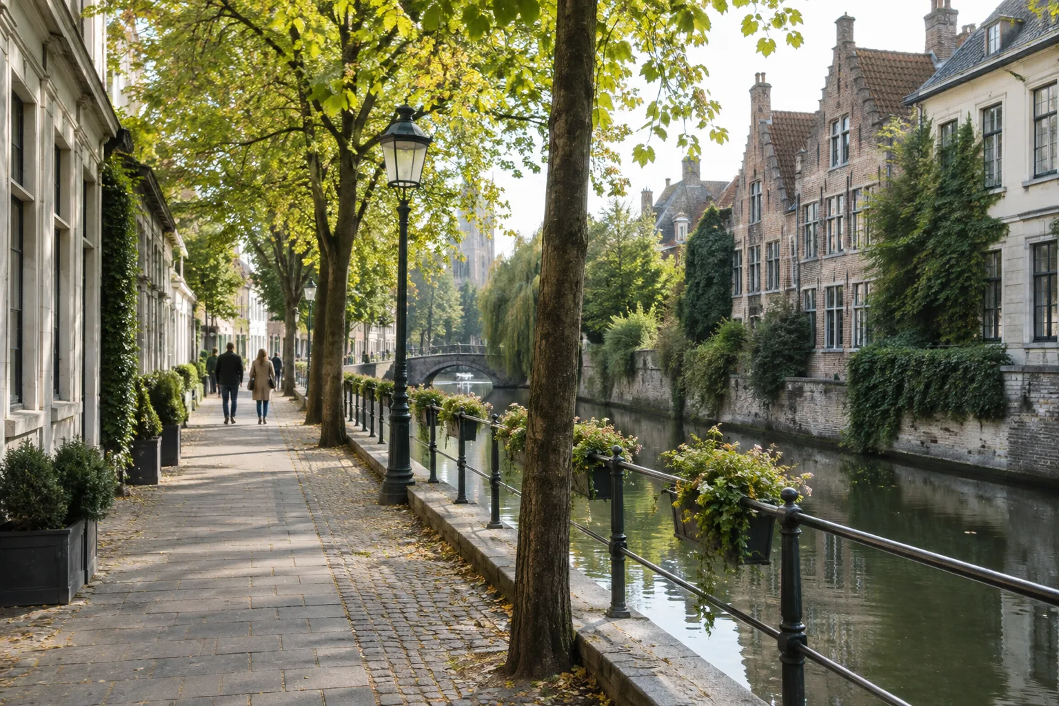 Un chemin piéton longe un canal bordé d’arbres et de bâtiments anciens.